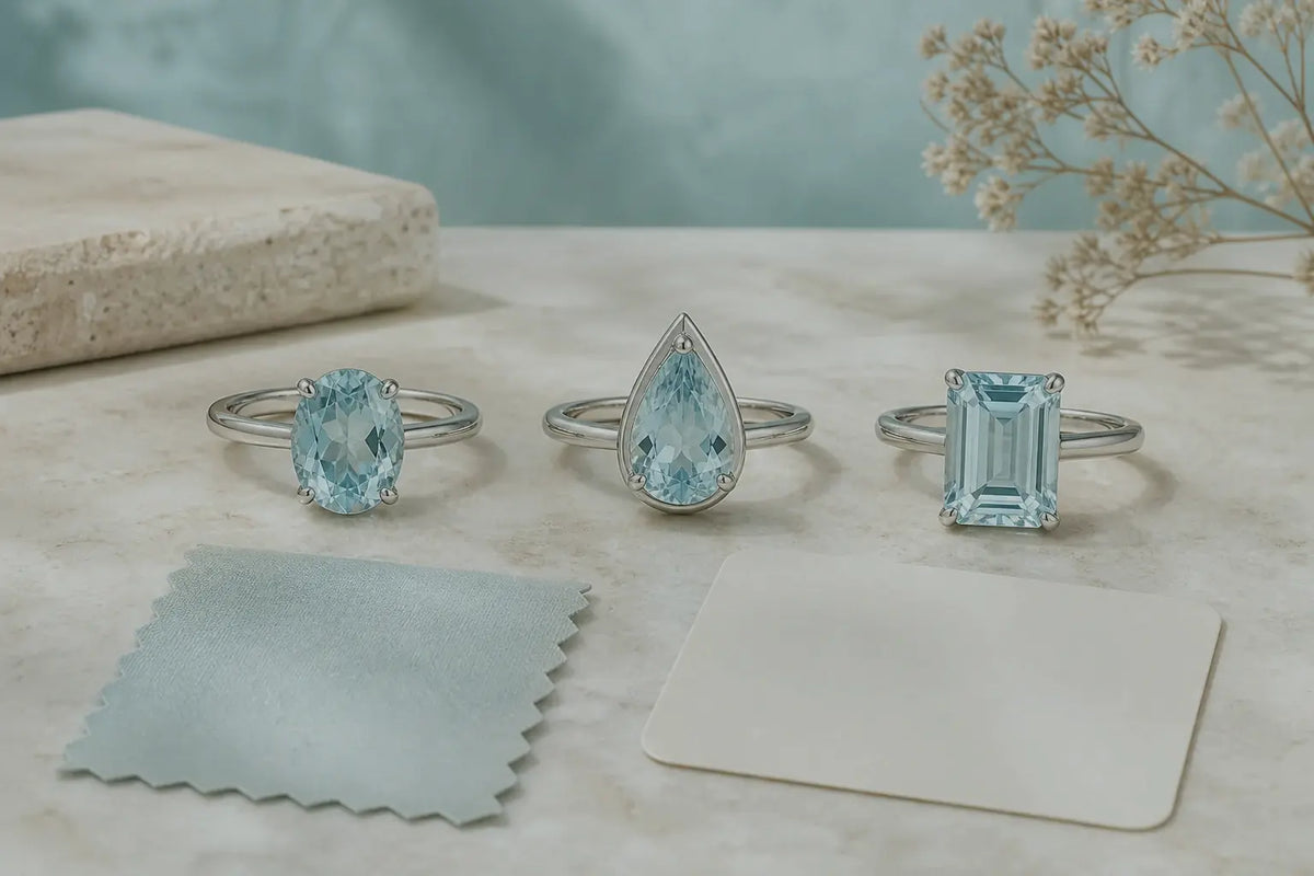 Three pale-blue aquamarine ring designs compared beside neutral color samples
